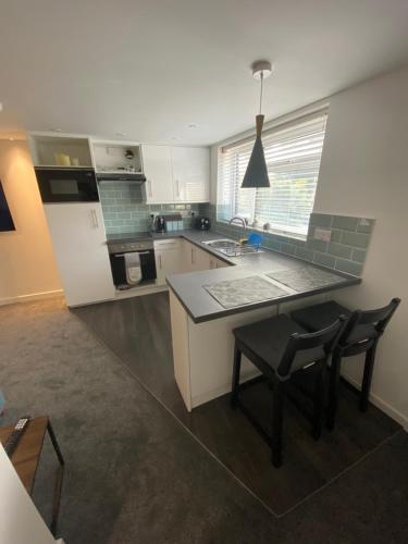 a kitchen with a counter and a table and chairs at modern 1 bed apartment with car parking in Bitton