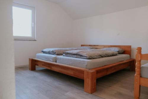 sypialnia z drewnianym łóżkiem w pokoju w obiekcie Kuca za odmor Nedo w mieście Kupres