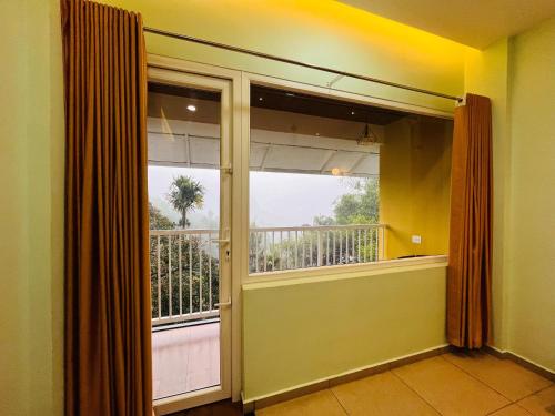 a room with a large window and a balcony at EDENS SNOW CASTLE in Anachal
