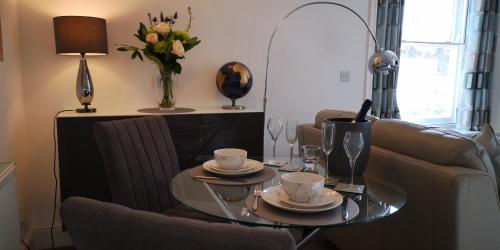 a living room with a glass table and a couch at Classy yet cosy and close to Chester City Centre in Chester
