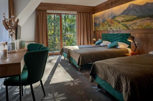 Un dormitorio con dos camas y un escritorio y una ventana. en Willa Maria 4, en Zakopane