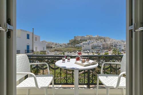 a table and chairs on a balcony with a view at Sofi pension in Naxos Chora