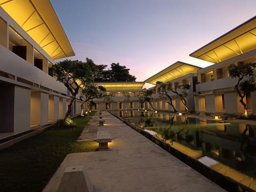 an empty courtyard of a building with trees and lights at Kuta Living by Kamara in Kuta