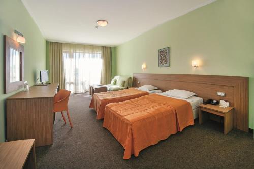 a hotel room with two beds and a desk at Jeravi Beach Hotel - All Inclusive in Sunny Beach