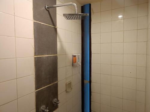 a shower in a bathroom with a blue pole at Kuta Living in Kuta