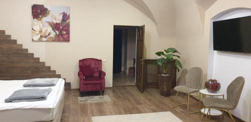 a room with a bed and a chair and a staircase at IMPERIAL ROOMS - ULTRACENTRAL - jacuzzi cu hidromasaj in Oradea