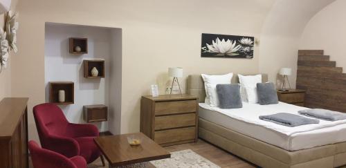 a bedroom with a bed and a chair and a table at IMPERIAL ROOMS - ULTRACENTRAL - jacuzzi cu hidromasaj in Oradea
