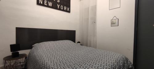 - une chambre dotée d'un lit et d'une nouvelle pancarte sur le mur dans l'établissement Rue de la coquille, à Béziers