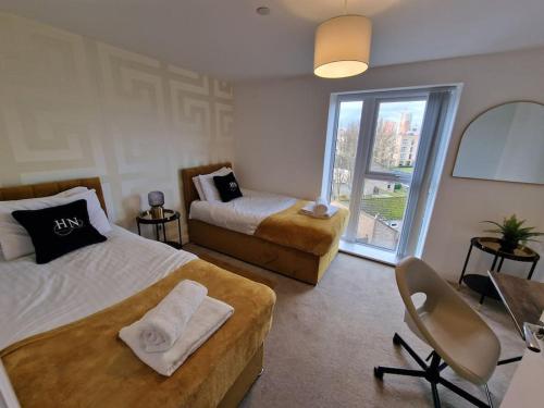 um quarto com 2 camas, uma cadeira e uma janela em Ideal for Families & Businesses em Birmingham