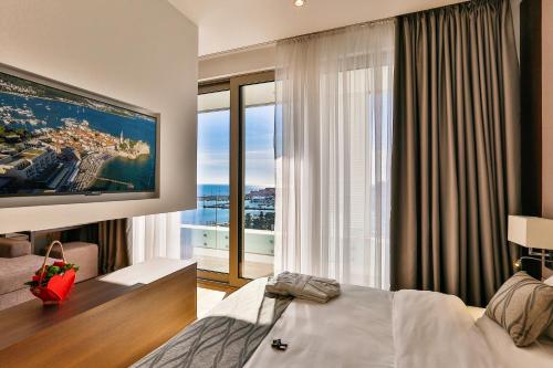 a hotel room with a bed and a large window at Victoria Apartments in Budva