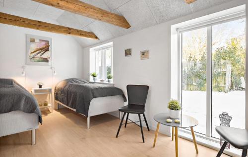 a bedroom with a bed and a table and a window at 3 Bedroom Stunning Home In Løkken in Løkken