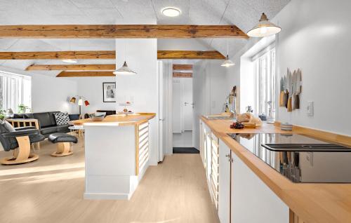 a kitchen with white counters and wooden ceilings at 3 Bedroom Stunning Home In Løkken in Løkken