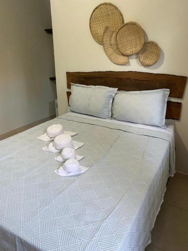 a bed with towels and hats on top of it at Pousada Dboa Milagres in São Miguel dos Milagres