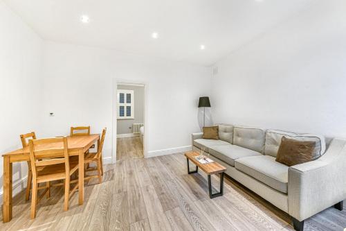 ein Wohnzimmer mit einem Sofa und einem Tisch in der Unterkunft The Knightsbridge Deluxe Apart in London