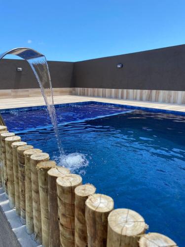 a swimming pool with a water fountain at Pousada Dboa Milagres in São Miguel dos Milagres