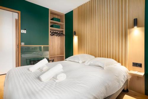 a large white bed in a room with green walls at Appartement standing -T3- Centre in Écully
