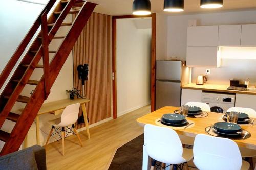 uma cozinha e sala de jantar com uma mesa de madeira e cadeiras em The Cozy Downtown Duplex em Chevreuse