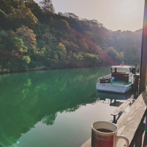 a cup of coffee sitting on a dock with a boat in the water at Ağva Güneş Otel in Sile