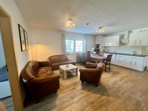 a living room with couches and a table and a kitchen at Ferienwohnung Kornkäfer 3 in Döbeln