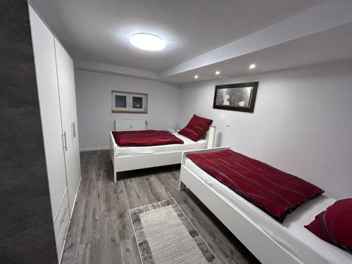 a bedroom with two beds with red sheets at Kleine Elbequelle 2 in Wolfhagen