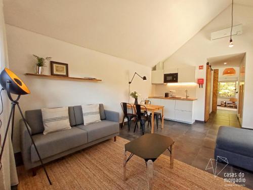 ein Wohnzimmer mit einem Sofa und einem Tisch in der Unterkunft Casas do Morgadio in Biscoitos