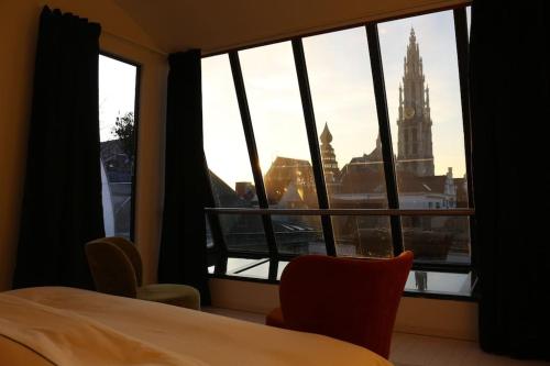 a room with a window with a view of a clock tower at The View in Antwerp