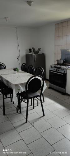 uma cozinha com uma mesa, cadeiras e um fogão em MarAzul em Valparaíso