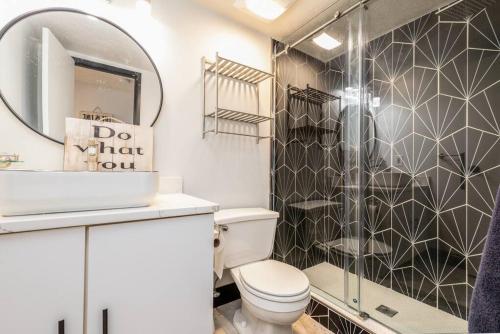 a bathroom with a shower and a toilet and a mirror at Urban Oasis: Work, Play, Unwind in Warehouse Dist in Cleveland