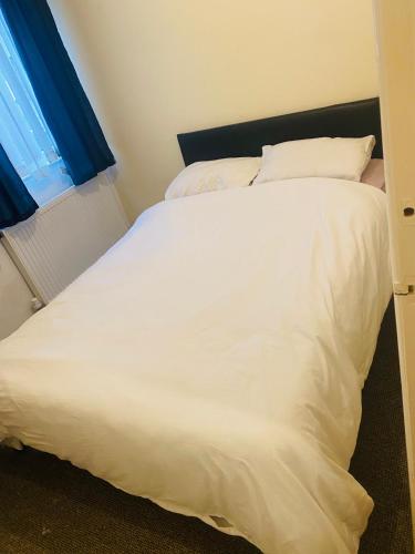a large white bed in a room with a window at Portable Single room in Bury