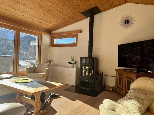 a living room with a wood stove and a tv at Chasa Stefania mit rundum Bergblick und Garten in Scuol