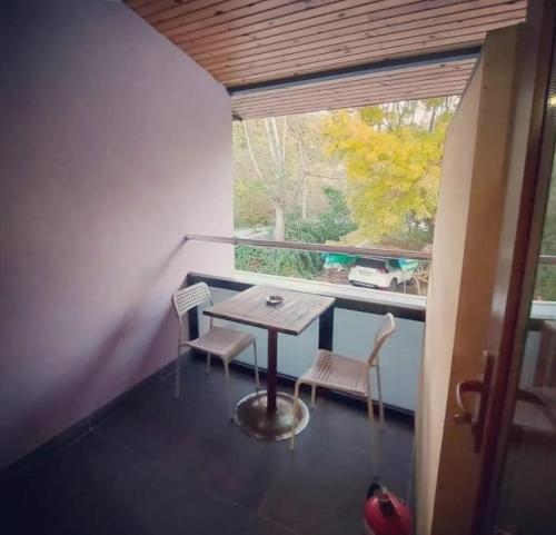 a small table and chairs on a balcony with a window at Ağva Güneş Otel in Sile