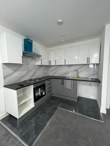 a kitchen with white cabinets and a stove top oven at A&K Inn in Bournemouth