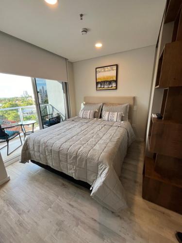a bedroom with a large bed and a balcony at Único apartamento in Asuncion