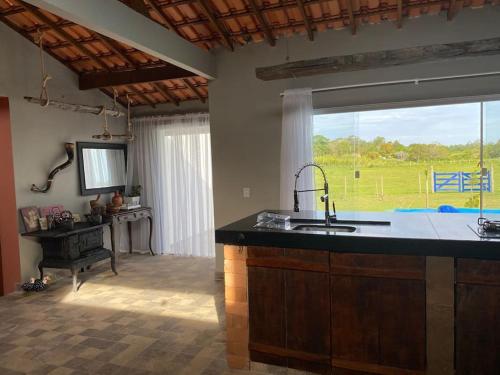 a kitchen with a sink and a large window at Casa de campo! Lugar de paz! Próxima as praias não oferecemos roupa de cama e banho in São Pedro da Aldeia