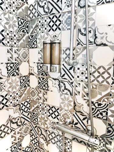 La salle de bains est revêtue de carrelage noir et blanc. dans l'établissement Appartement Neuf - Vue Océan 50m - Sud - balcon - Calme, à La Pironnière