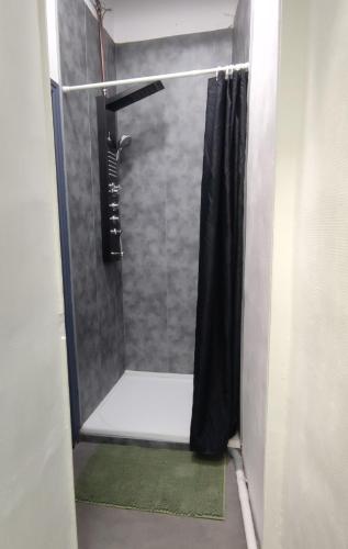 La salle de bains est pourvue d'une douche avec rideau de douche noir. dans l'établissement Rue de la coquille, à Béziers