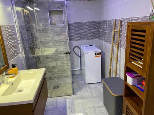a bathroom with a shower and a sink and a refrigerator at Labellapose in Le Diamant