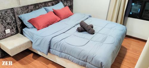 a bed with a blue comforter and pillows on it at i-City【CASA MILA】~Wifi/Netflix/Parking~7pax in Shah Alam