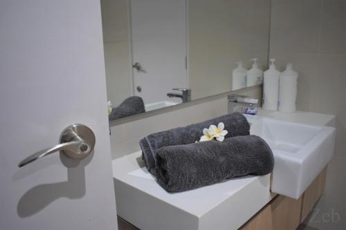 a bathroom with a sink and a towel at i-City【CASA MILA】~Wifi/Netflix/Parking~7pax in Shah Alam