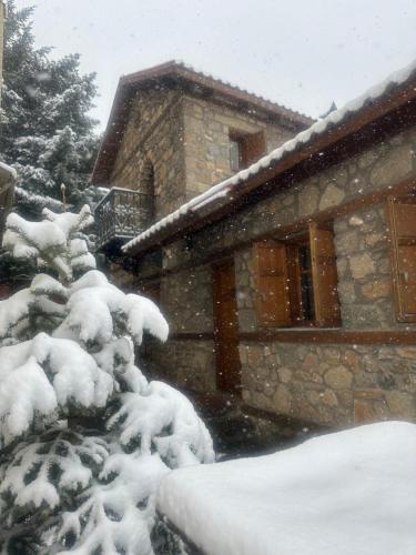 a house covered in snow in front of a house at Urban River House in Florina