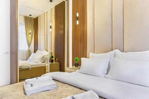 a bedroom with a large white bed and a mirror at Ama Garden Apartment Busteni in Buşteni