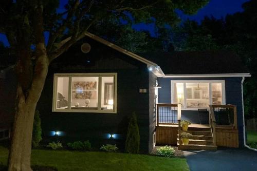 una pequeña casa negra con porche por la noche en Maple Blue en San Juan de Terranova