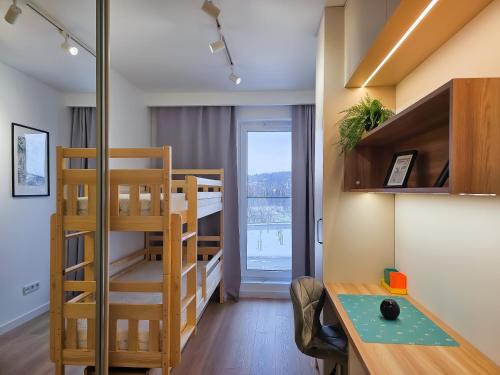 a small room with a bunk bed and a desk at Aurum Apartamenty Nowy Sącz Aleje Piłsudskiego 20 Bezpłatny parking! in Nowy Sącz
