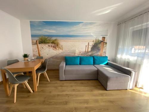 a living room with a couch and a beach mural at Apartament NALA in Mediaş