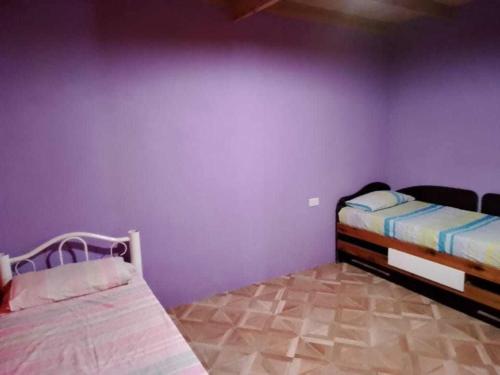 1 dormitorio con 2 camas y pared púrpura en Mis tres soles en Miramar