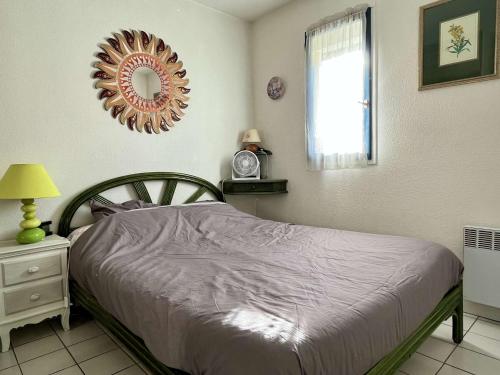 een slaapkamer met een bed en een spiegel aan de muur bij Appartement Argelès-sur-Mer, 2 pièces, 4 personnes - FR-1-225-680 in Argelès-sur-Mer