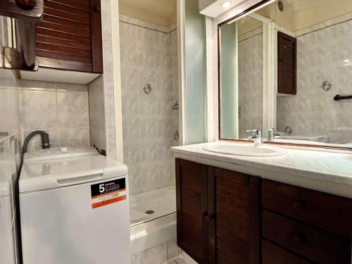een badkamer met een wastafel, een spiegel en een bad bij Appartement Argelès-sur-Mer, 2 pièces, 4 personnes - FR-1-225-680 in Argelès-sur-Mer