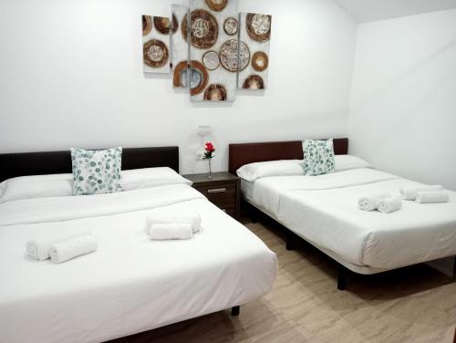2 camas en una habitación con platos en la pared en Estancia Cecilia en La Orotava