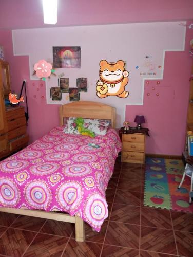 La casita de la abuela في كاخاماركا: غرفة نوم مع سرير مع جدار مرحبا كيتي