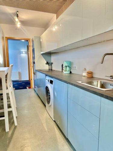 a kitchen with a sink and a washing machine at Gästehaus Weserblick am Weser-Sandstrand in Berne